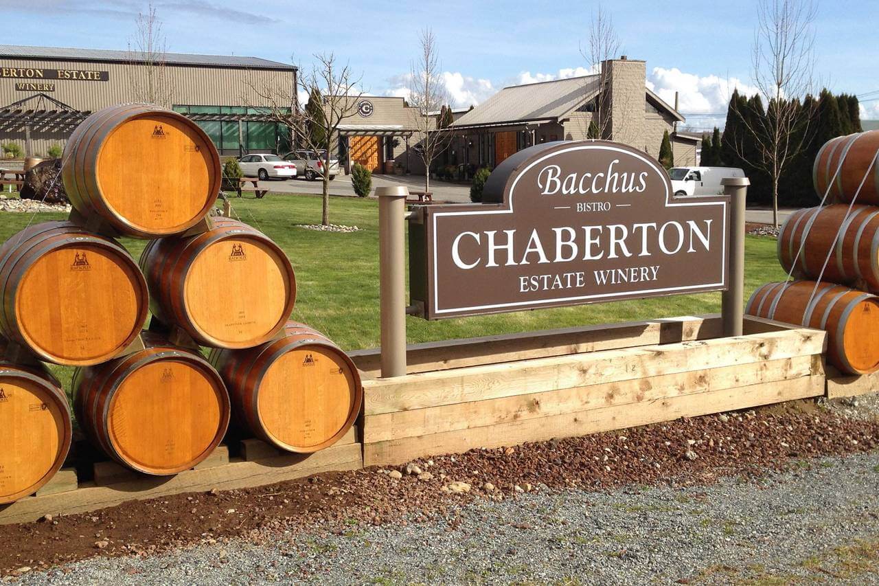 Chaberton Winery sign with aged wooden barrels on either side