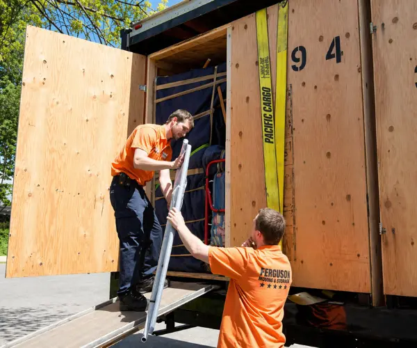 Two Ferguson movers puttiong equipment into storage