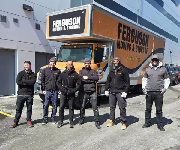 A team of movers standing in front of a Ferguson Moving truck