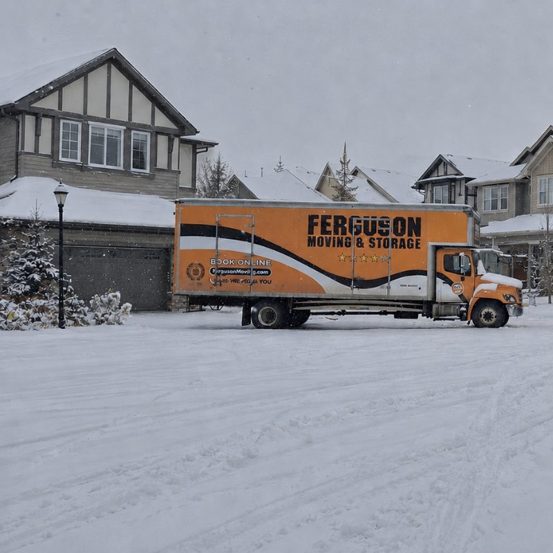 Ferguson Moving Truck parking in the snow in front of a single family home in Calgary.