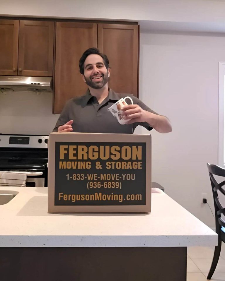 Ferguson team member packing a mug into a Ferguson moving box on a kitchen counter